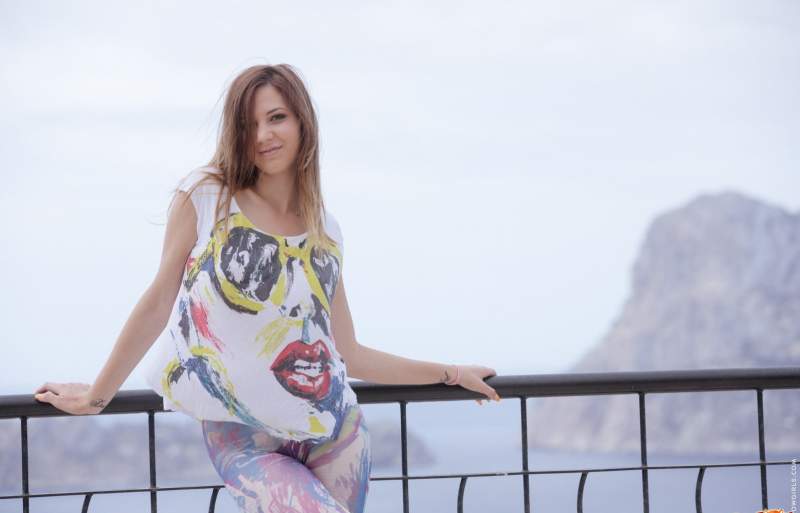 На балконе обнажилась молодая женщина в лосинах и кедах.