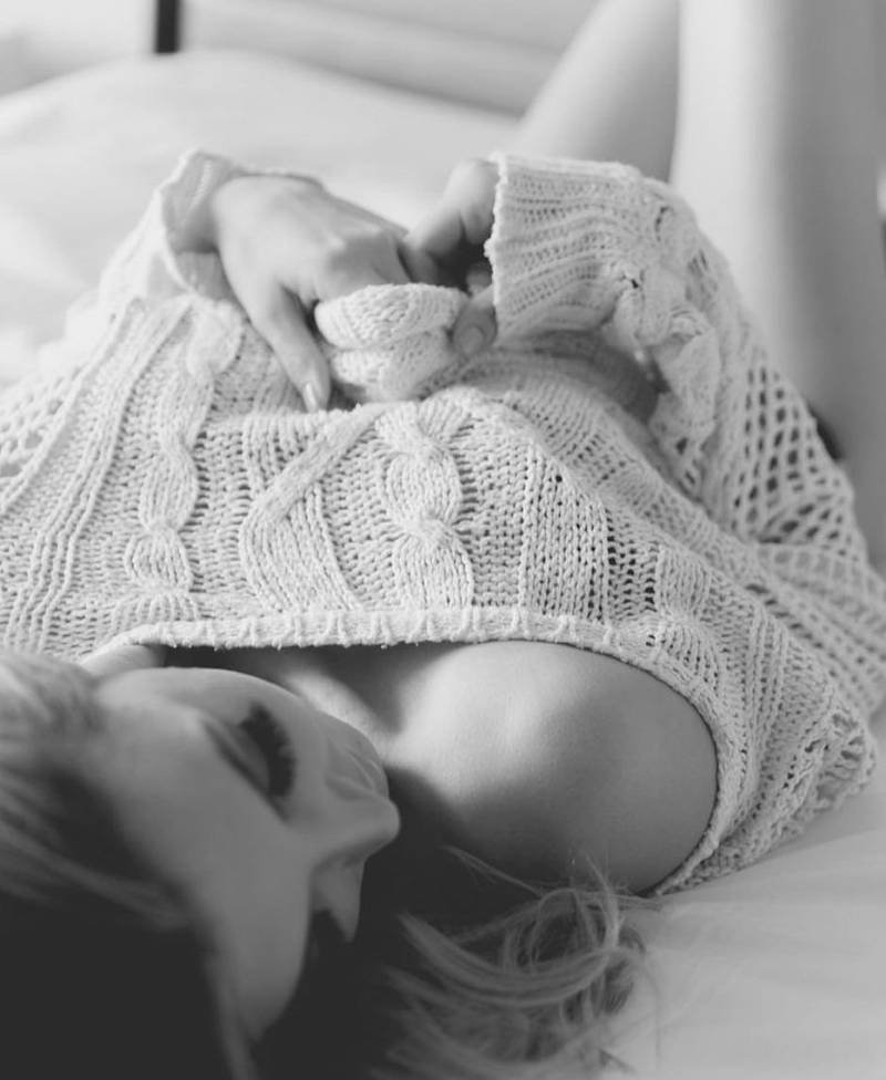 Девушка в свитере на кровати